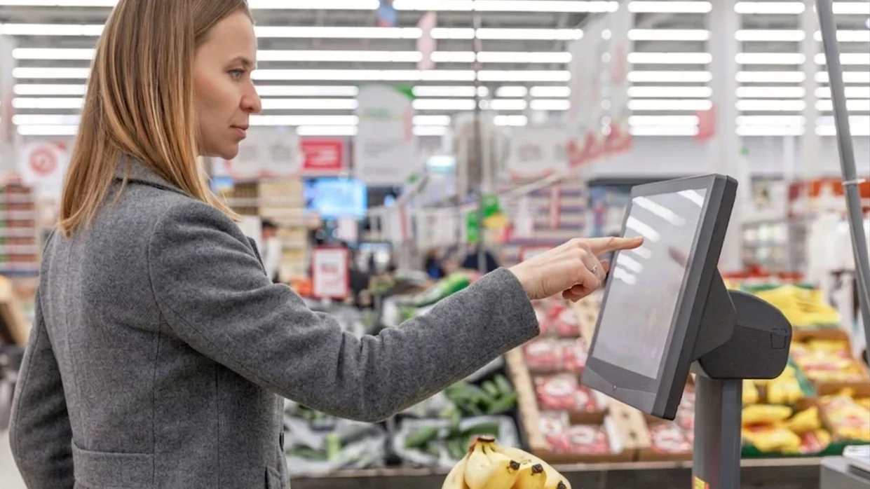 cliente utilizando sistema PDV em supermercado, registrando produtos e garantindo agilidade no atendimento